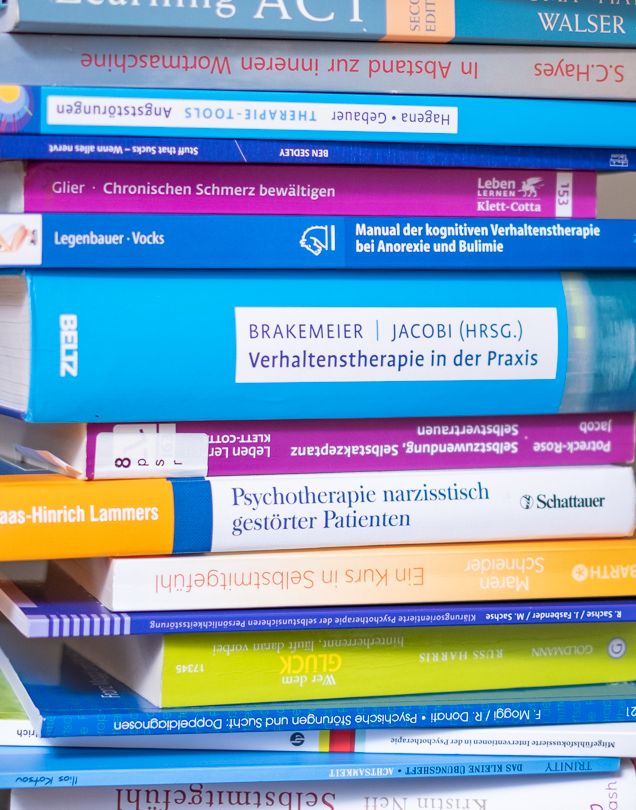 Ein Stapel psychotherapeutischer Fachbücher zu unterschiedlichen Themen